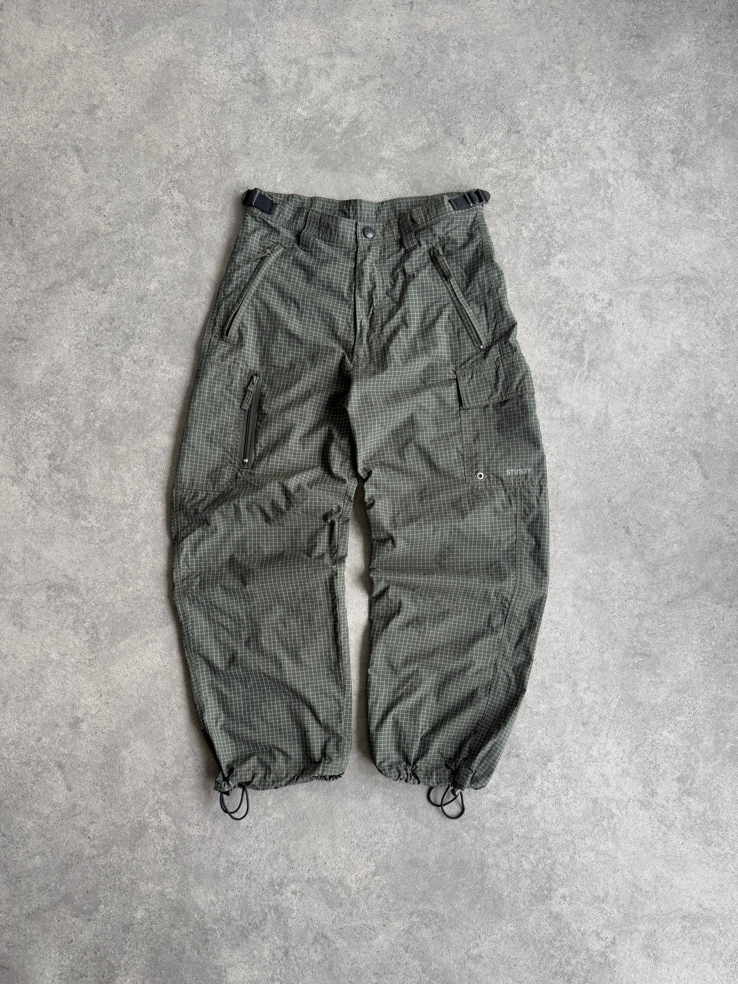 stussy 1990s technical parachute pants in olive grid, front view