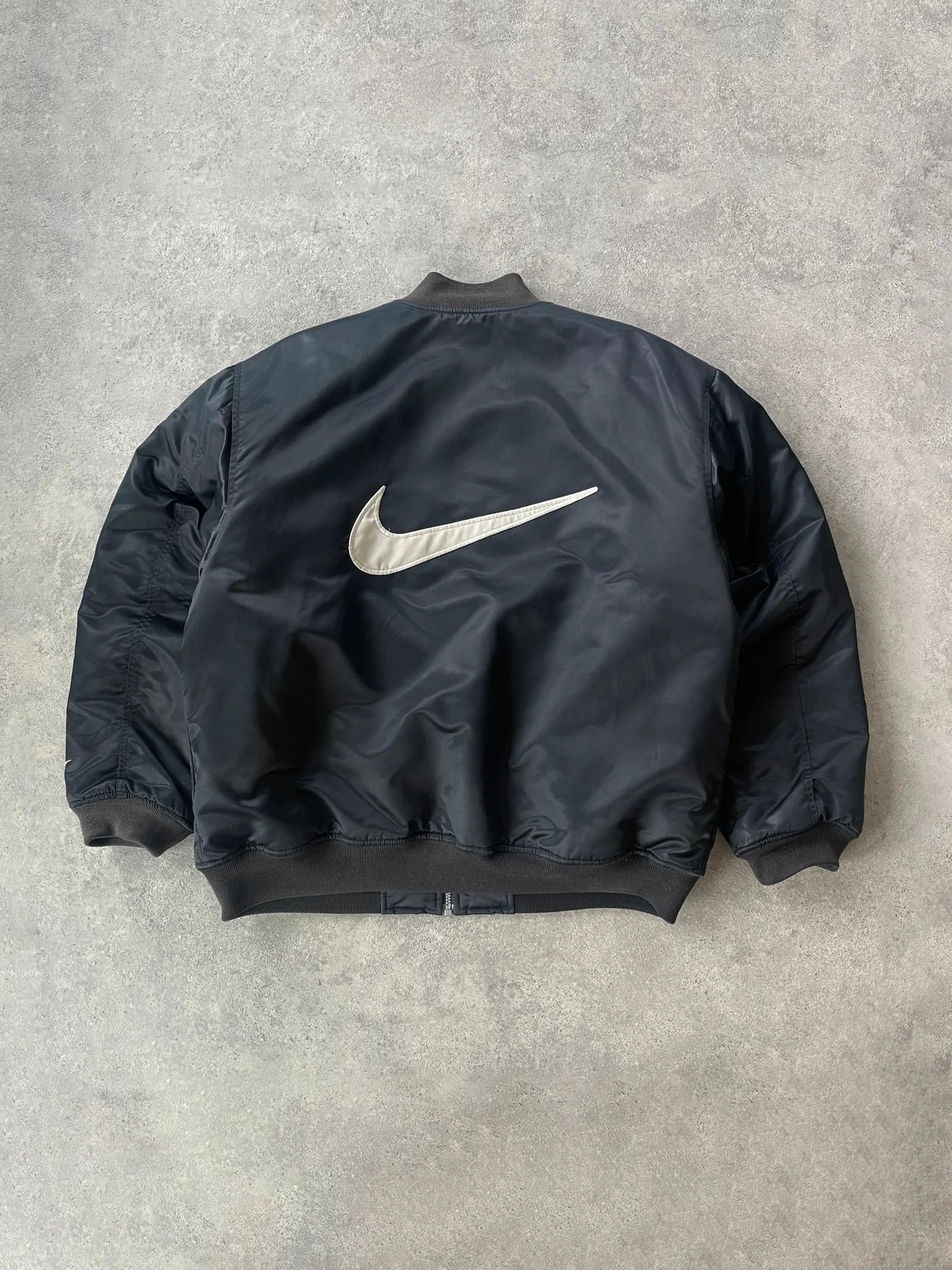 nike 1990s heavyweight padded bomber jacket in black, back with oversized swoosh