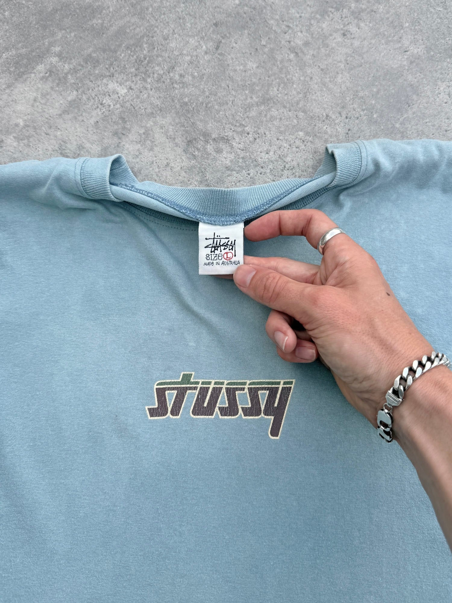 stussy 1990s single stitch graphic t-shirt in faded sky blue, back oval graphic view